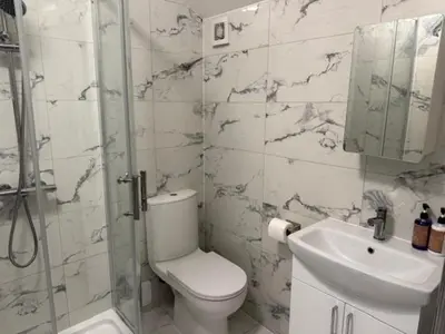 a bathroom with a toilet and a sink and a shower at Adrian House Blackpool in Blackpool