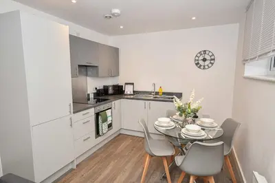 a kitchen with a table and chairs in a kitchen at Modern 2 Bedroom Apartment in Central Wigan in Wigan