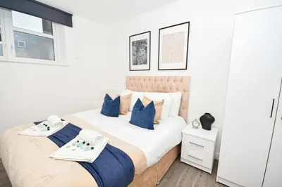a bedroom with a large bed with blue pillows at Modern 2 Bedroom Apartment in Central Wigan in Wigan