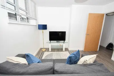 a living room with a couch and a tv at Modern 2 Bedroom Apartment in Central Wigan in Wigan