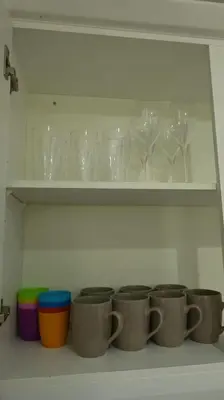 a row of cups on a shelf with glasses at Whole House in Liverpool, Merseyside in Liverpool
