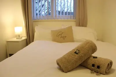 a bed with a teddy bear sitting on top of it at Whole House in Liverpool, Merseyside in Liverpool