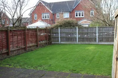 a backyard with a fence and a yard at Whole House in Liverpool, Merseyside in Liverpool