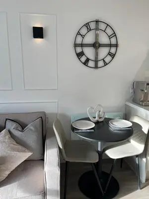 a dining room with a table and a clock on the wall at Liverpool Central City Centre Modern Apartment - Sleeps 4 in Liverpool