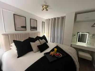 a bedroom with a bed with a tray of food on it at Liverpool Central City Centre Modern Apartment - Sleeps 4 in Liverpool