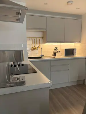 a kitchen with white cabinets and a counter top at Liverpool Central City Centre Modern Apartment - Sleeps 4 in Liverpool