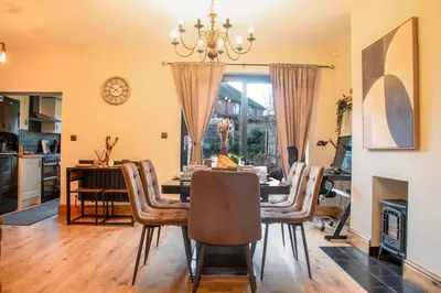 a dining room with a table and chairs at Elegant Bolton Home Garden Free Parking Sleeps 7 in Bolton