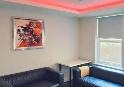 a living room with a couch and a painting on the wall at The Red Lounge House Near Anfield sleeps 14 LFC in Liverpool