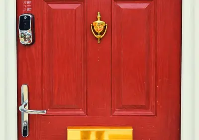 a red door with a crest on it at The Red Lounge House Near Anfield sleeps 14 LFC in Liverpool