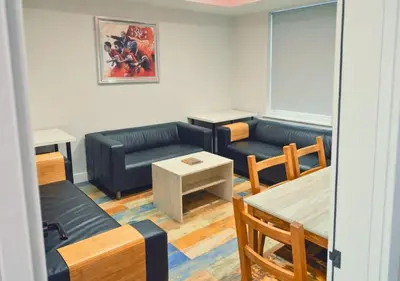 a living room with a couch and a table at The Red Lounge House Near Anfield sleeps 14 LFC in Liverpool