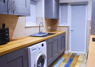 a kitchen with a sink and a washing machine at The Red Lounge House Near Anfield sleeps 14 LFC in Liverpool