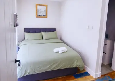a bedroom with a bed with two towels on it at The Red Lounge House Near Anfield sleeps 14 LFC in Liverpool