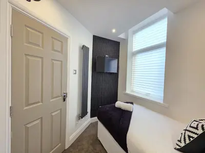 a room with a door and a window and a couch at Anfield 4 min walk Sleeps 7 4BR 5Bed 3Bathrooms in Liverpool