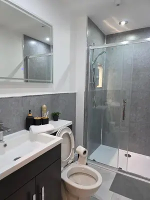 a bathroom with a toilet and a glass shower at Anfield 4 min walk Sleeps 7 4BR 5Bed 3Bathrooms in Liverpool