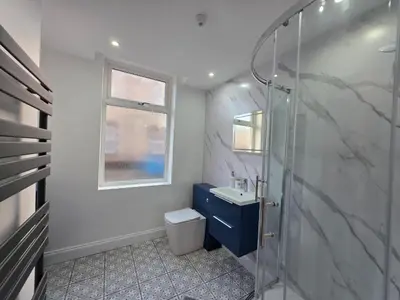a bathroom with a shower and a toilet and a sink at Anfield 4 min walk Sleeps 7 4BR 5Bed 3Bathrooms in Liverpool