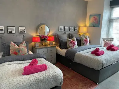 two beds with pink towels on them in a bedroom at Mayfield House-Private Hosted Stay with Breakfast in Blackpool