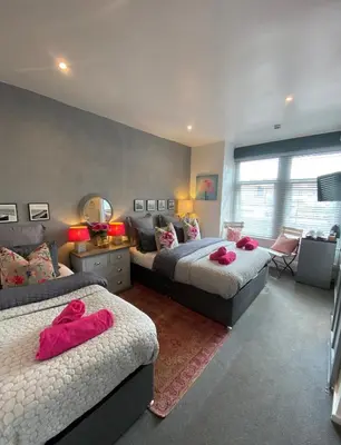 a bedroom with two beds with pink towels on them at Mayfield House-Private Hosted Stay with Breakfast in Blackpool