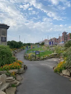 a walkway in a park with flowers and buildings at Mayfield House-Private Hosted Stay with Breakfast in Blackpool