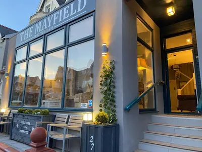 a store with tables and chairs in front of a building at Mayfield House-Private Hosted Stay with Breakfast in Blackpool