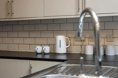 a kitchen counter with a sink and a faucet at Colquitt House - Air Host & Stay - 8BR Sleeps 16 in Liverpool