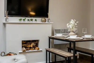 a living room with a table and a fireplace at Colquitt House - Air Host & Stay - 8BR Sleeps 16 in Liverpool