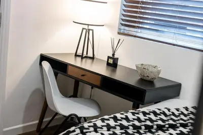 a desk with a white chair next to a bed at Colquitt House - Air Host & Stay - 8BR Sleeps 16 in Liverpool
