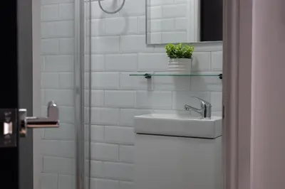 a white bathroom with a sink and a mirror at Colquitt House - Air Host & Stay - 8BR Sleeps 16 in Liverpool