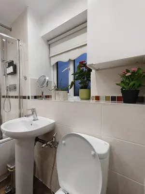 a white bathroom with a toilet and a sink at Hanani House in Liverpool
