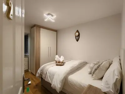 a bedroom with a bed and a clock on the wall at Hanani House in Liverpool