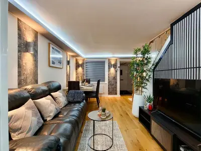 a living room with a leather couch and a television at Hanani House in Liverpool