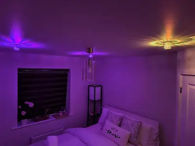 a purple room with a couch and a window with purple lights at Hanani House in Liverpool