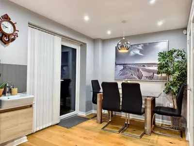 a dining room with a table and chairs and a clock at Hanani House in Liverpool