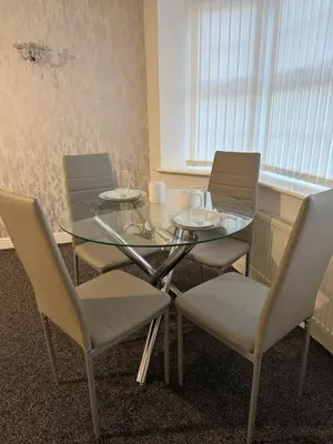 a glass table and chairs in a room at Nightingale Roomz in Lower Darwen