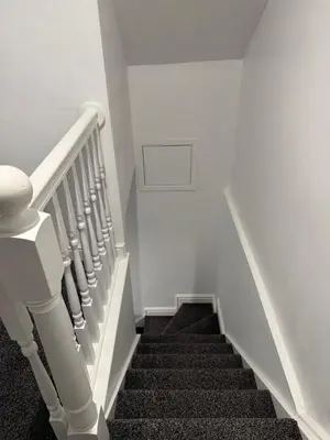 a stairway with a spiral staircase in a house at Nightingale Roomz in Lower Darwen