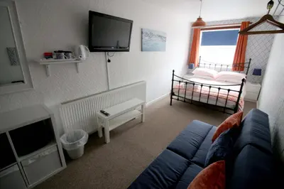 a living room with a blue couch and a tv at Shipping Lanes Hotel in Morecambe
