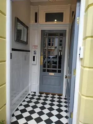 a hallway with a blue door and a checkered floor at The Castleton in Blackpool