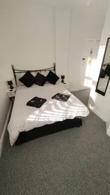 a bedroom with a bed with black pillows at The Castleton in Blackpool