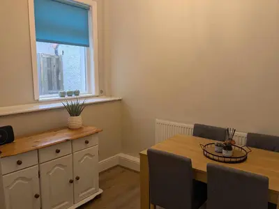 a dining room with a table and a window at STANLEY HOUSE MORECAMBE Modern spacious 3 bed family home near seafront in Heysham
