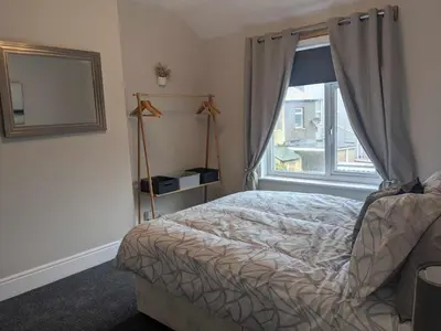 a bedroom with a bed and a window at STANLEY HOUSE MORECAMBE Modern spacious 3 bed family home near seafront in Heysham