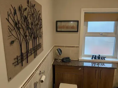 a bathroom with a toilet and a window at STANLEY HOUSE MORECAMBE Modern spacious 3 bed family home near seafront in Heysham