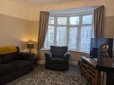 a living room with a couch and a chair and a tv at STANLEY HOUSE MORECAMBE Modern spacious 3 bed family home near seafront in Heysham