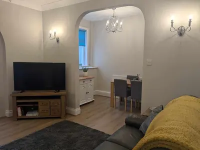 a living room with a couch and a flat screen tv at STANLEY HOUSE MORECAMBE Modern spacious 3 bed family home near seafront in Heysham