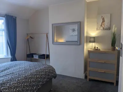 a bedroom with a bed and a picture on the wall at STANLEY HOUSE MORECAMBE Modern spacious 3 bed family home near seafront in Heysham