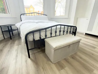 a bedroom with a bed with a bench next to it at Princes road hidden gem in Liverpool