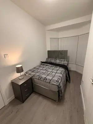 a bedroom with two beds and a nightstand with a lamp at Stylish Dream Home with 4 En-Suite Bedrooms in Liverpool