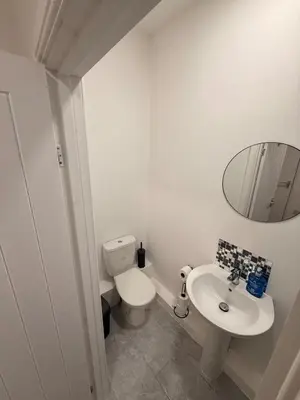 a bathroom with a toilet and a sink and a mirror at Stylish Dream Home with 4 En-Suite Bedrooms in Liverpool