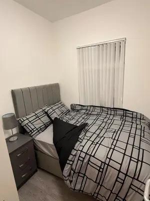 a bedroom with a black and white bed and a window at Stylish Dream Home with 4 En-Suite Bedrooms in Liverpool