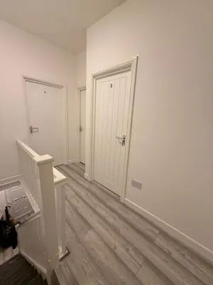an empty hallway with white walls and wooden floors at Stylish Dream Home with 4 En-Suite Bedrooms in Liverpool