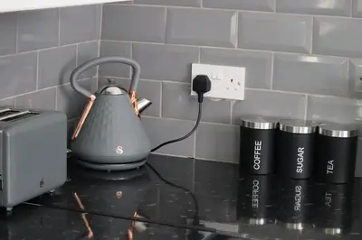 a tea kettle and three cups on a counter at Anfield 5bed 5bath cosy group retreat in Liverpool