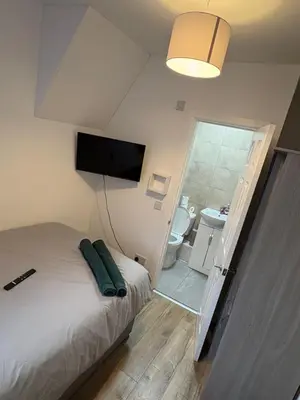 a bedroom with a bed and a flat screen tv at Anfield 5bed 5bath cosy group retreat in Liverpool